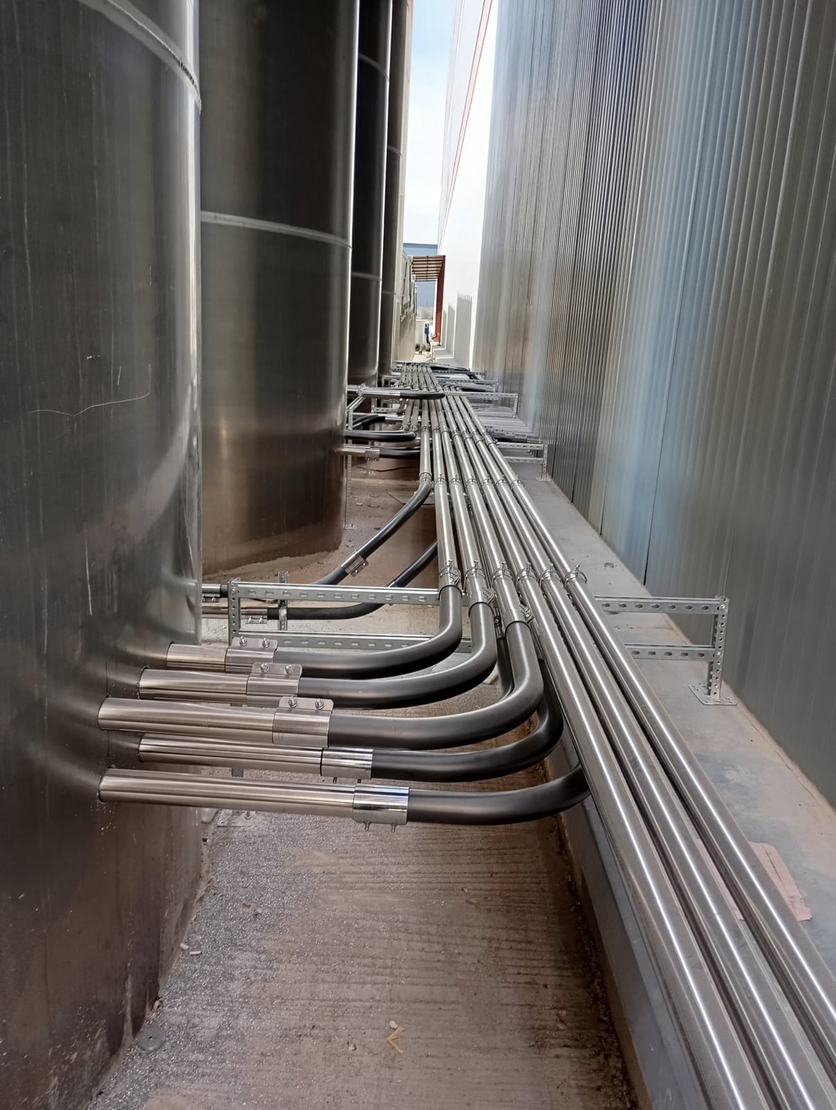 Stainless raw-material conveying lines running from the silos to the production lines